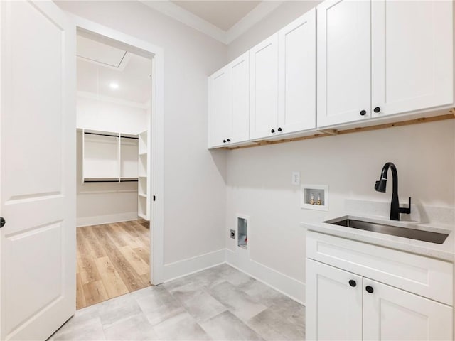 laundry room featuring cabinets, sink, washer hookup, crown molding, and light hardwood / wood-style flooring