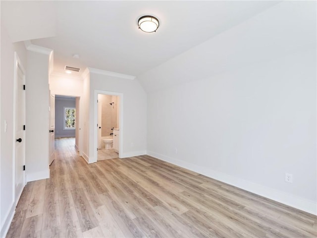 spare room with light wood-type flooring and vaulted ceiling