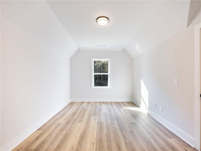 additional living space with vaulted ceiling and light hardwood / wood-style floors