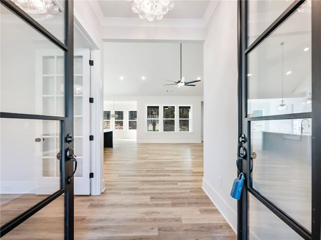 hallway with light wood-type flooring and a chandelier