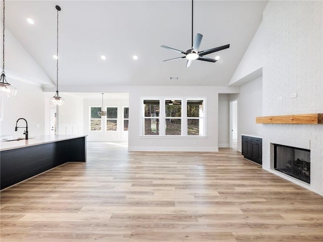 unfurnished living room featuring light hardwood / wood-style floors, a healthy amount of sunlight, and high vaulted ceiling