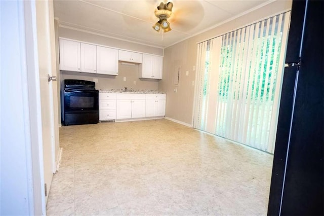 kitchen with sink, ceiling fan, stove, white cabinetry, and black fridge