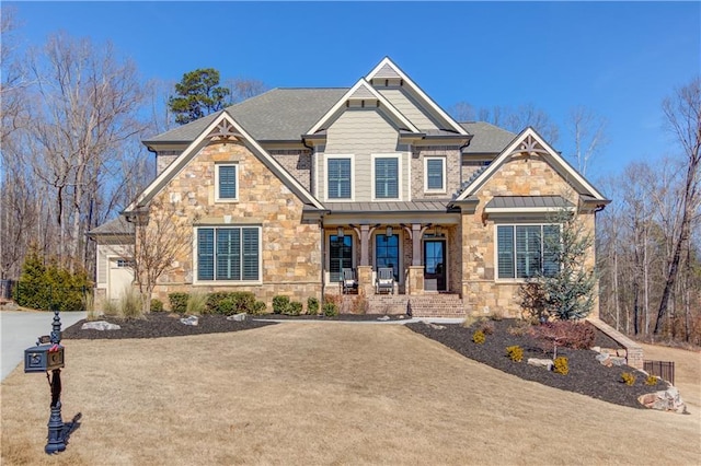 craftsman-style home featuring stone siding, covered porch, metal roof, and a standing seam roof