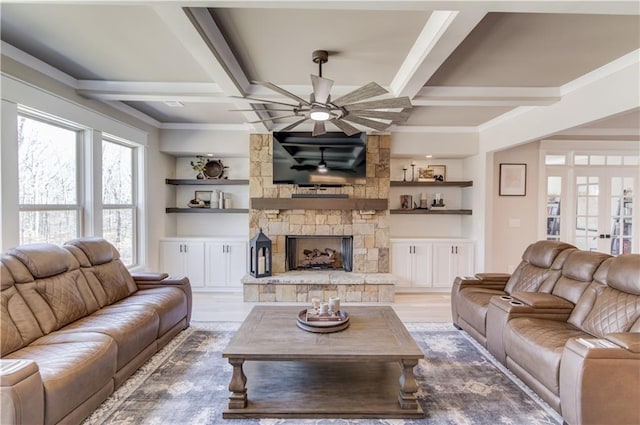 living room featuring coffered ceiling, wood finished floors, and a stone fireplace