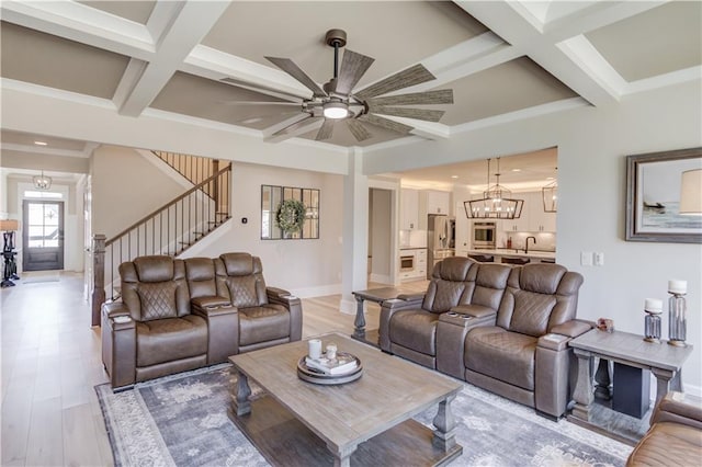 living area with light wood finished floors, stairs, coffered ceiling, and beamed ceiling