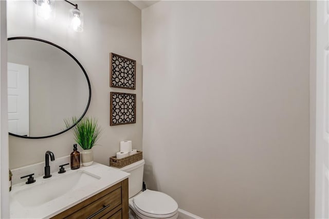 half bathroom featuring vanity and toilet