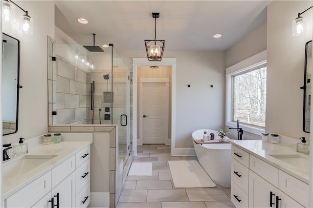 full bath with a stall shower, two vanities, a freestanding tub, and a sink