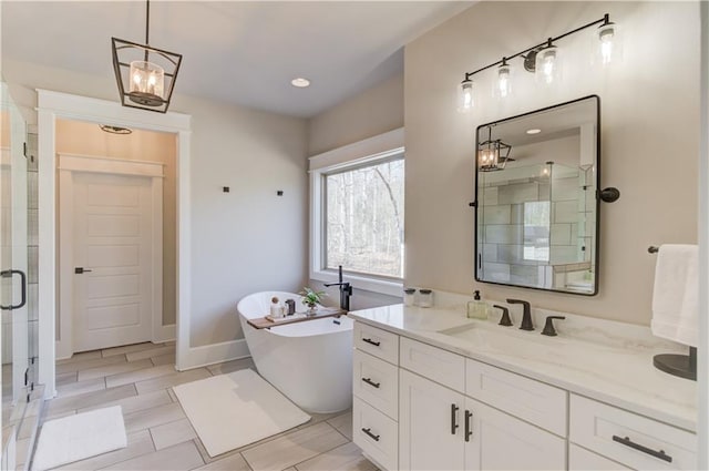 full bathroom featuring a stall shower, a soaking tub, vanity, and baseboards