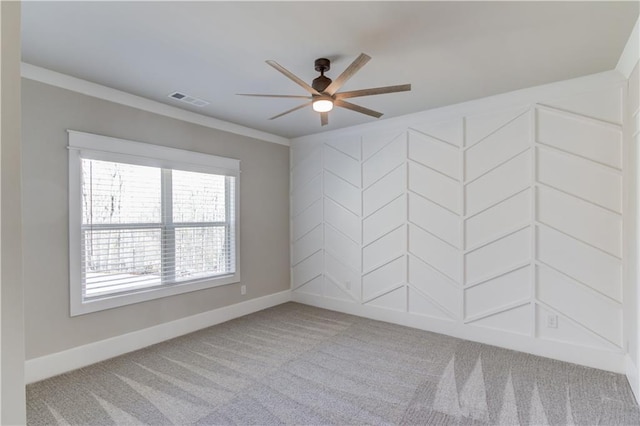 spare room with visible vents, a ceiling fan, ornamental molding, light carpet, and baseboards