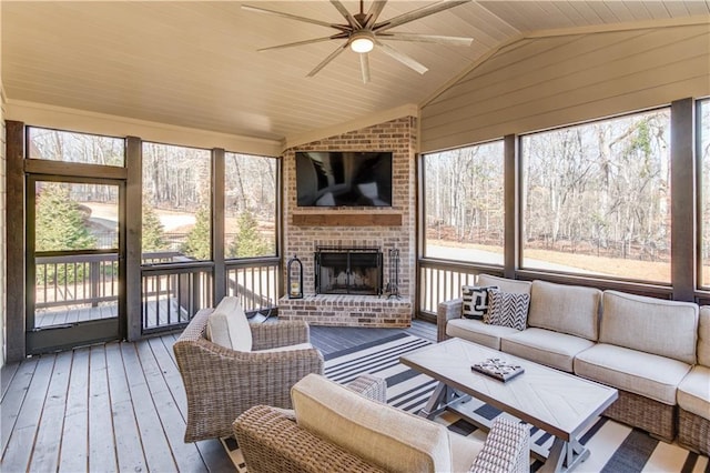 sunroom / solarium with lofted ceiling, an outdoor brick fireplace, and ceiling fan