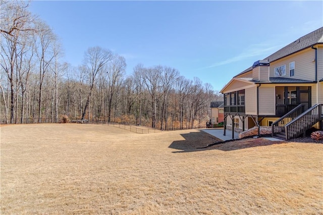 view of yard with a sunroom and stairs