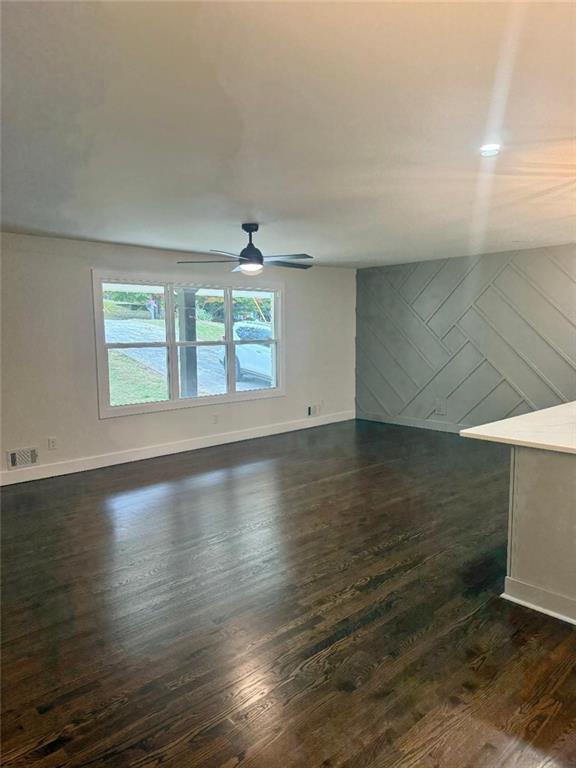 unfurnished room featuring ceiling fan and dark hardwood / wood-style flooring