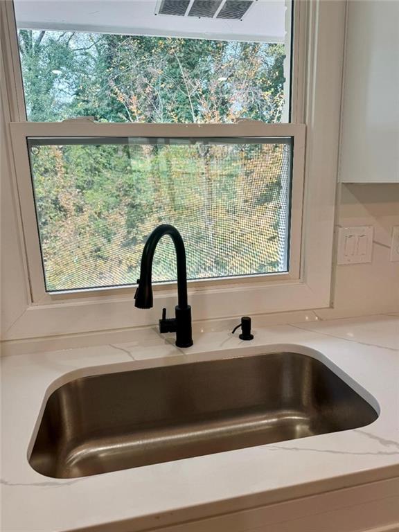 room details featuring sink and light stone counters