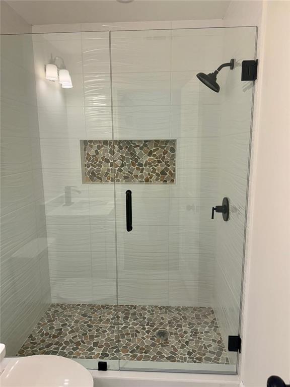 bathroom with toilet and walk in shower