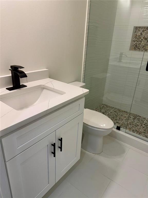 bathroom with vanity, an enclosed shower, and toilet