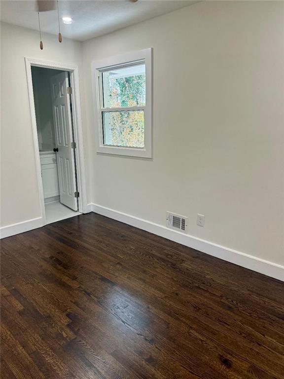 unfurnished room with dark hardwood / wood-style floors and ceiling fan