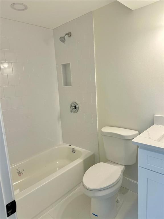 full bathroom with vanity, toilet, tiled shower / bath combo, and tile patterned flooring