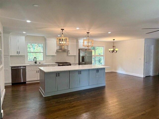 kitchen featuring dark wood-type flooring, sink, a center island, white cabinetry, and appliances with stainless steel finishes