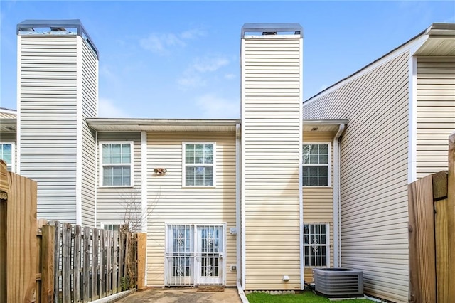 back of house featuring a patio area, cooling unit, a chimney, and fence