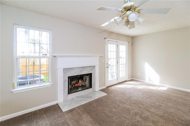 unfurnished living room featuring baseboards, a textured ceiling, carpet, and a premium fireplace