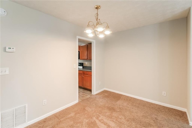 unfurnished dining area featuring baseboards, light colored carpet, visible vents, and a chandelier