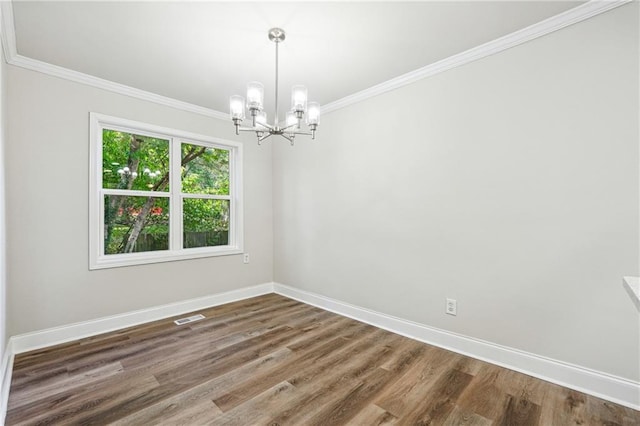 empty room with crown molding, a chandelier, and hardwood / wood-style flooring