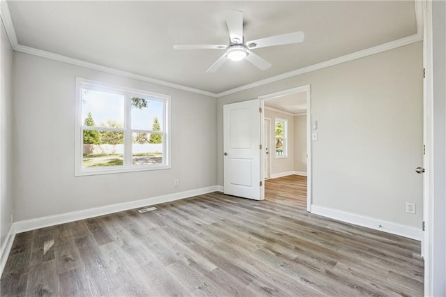 unfurnished bedroom featuring ornamental molding, light wood-type flooring, ceiling fan, and multiple windows