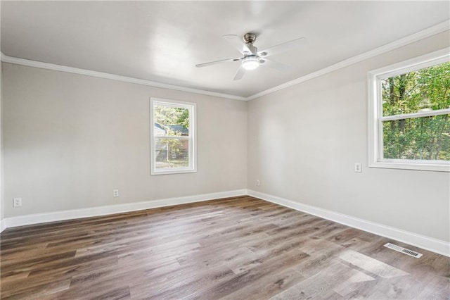 empty room with ceiling fan, crown molding, and hardwood / wood-style floors