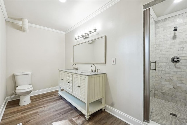 bathroom with vanity, hardwood / wood-style flooring, ornamental molding, toilet, and an enclosed shower