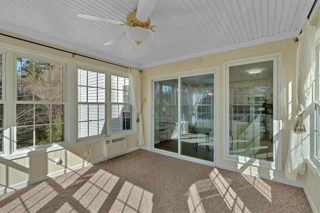 unfurnished sunroom with ceiling fan and a wall mounted AC