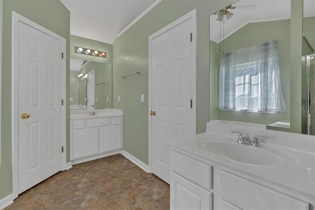 bathroom with lofted ceiling, ceiling fan, baseboards, and vanity