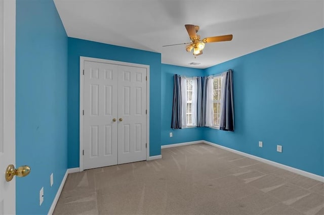 unfurnished bedroom with ceiling fan, carpet flooring, visible vents, baseboards, and a closet