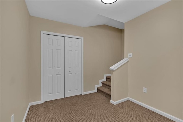 interior space featuring lofted ceiling, a closet, baseboards, and carpet flooring