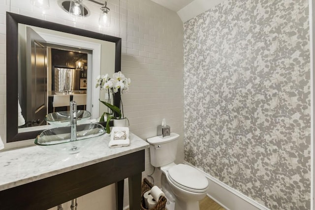 full bathroom with a shower with curtain, tile walls, toilet, and a sink