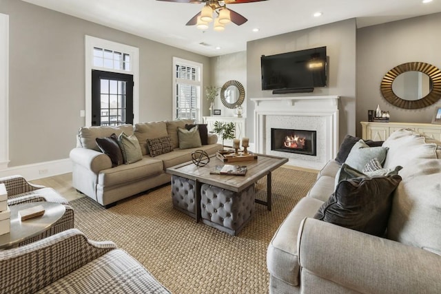 living room featuring recessed lighting, baseboards, a glass covered fireplace, and a ceiling fan