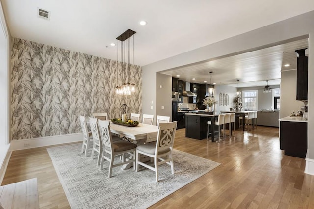 dining area featuring wallpapered walls, recessed lighting, visible vents, and an accent wall