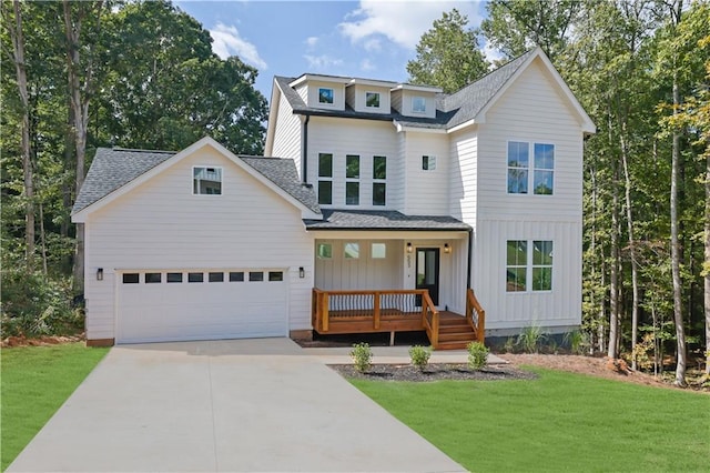 view of front of house featuring a garage, a front yard, and a porch