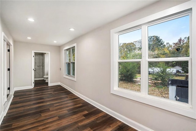 hall featuring dark wood-style floors, baseboards, and recessed lighting