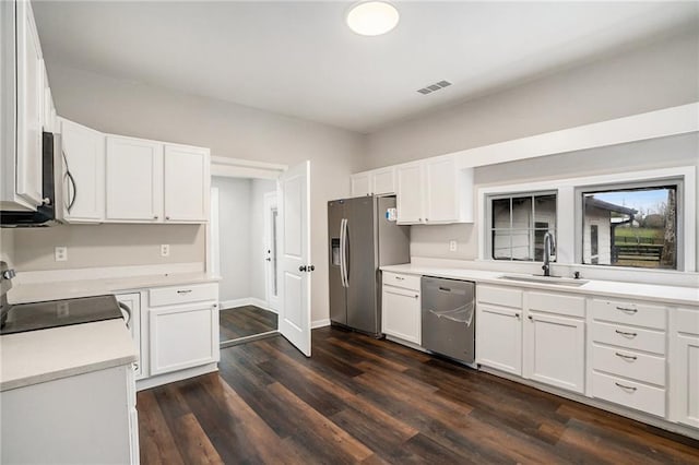 kitchen with dark wood-style flooring, a sink, visible vents, white cabinets, and appliances with stainless steel finishes