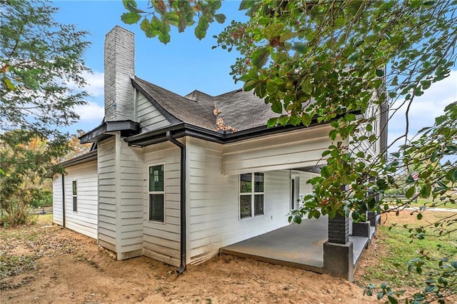 view of home's exterior featuring a patio and a chimney