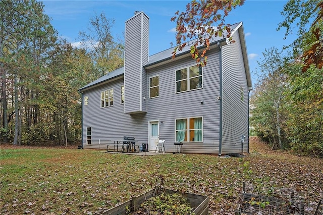 back of property featuring a patio area and a yard