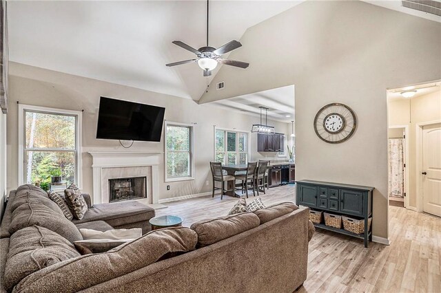 living room featuring high vaulted ceiling, light wood-type flooring, and ceiling fan