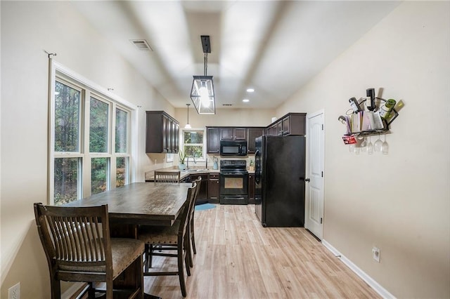 dining area featuring light wood-type flooring, sink, and a healthy amount of sunlight