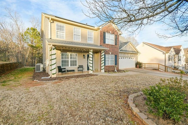 view of front of property featuring driveway, an attached garage, fence, cooling unit, and a porch