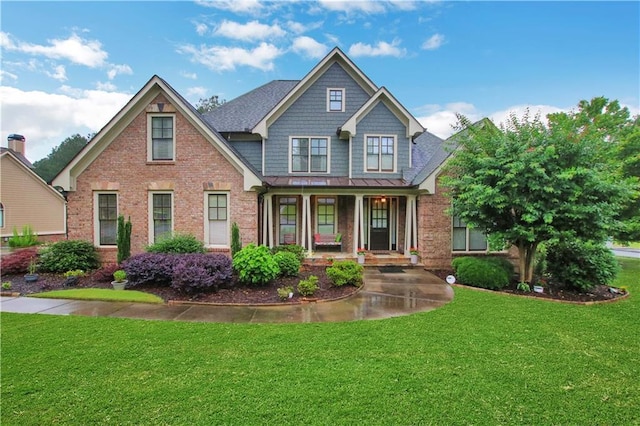 26 Trillium Ln, Acworth, GA 30101 - craftsman-style house featuring covered porch, brick siding, a front yard, and a standing seam roof