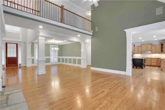 26 Trillium Ln, Acworth, GA 30101 - unfurnished living room featuring ornate columns, a towering ceiling, a chandelier, ornamental molding, and ceiling fan