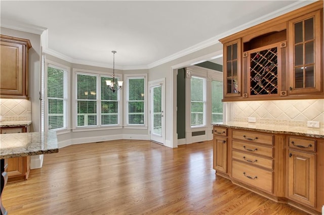 26 Trillium Ln, Acworth, GA 30101 - kitchen with a chandelier, light wood finished floors, light stone counters, glass insert cabinets, and crown molding