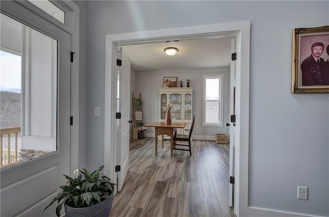 corridor featuring baseboards and wood finished floors