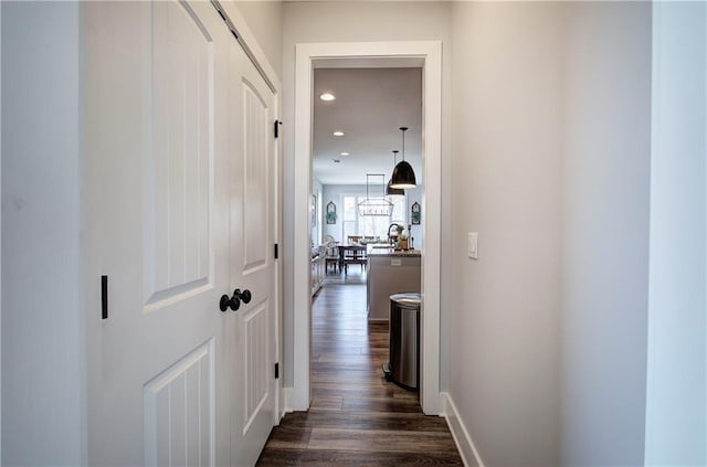 corridor with dark wood-style floors, recessed lighting, and baseboards