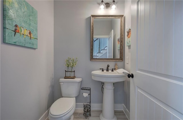 half bath with toilet and baseboards